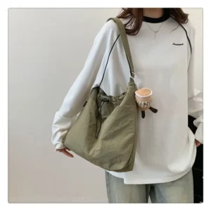 Nylon bucket crossbody bag for women in black, lightweight casual shoulder bag with pendant option for everyday use