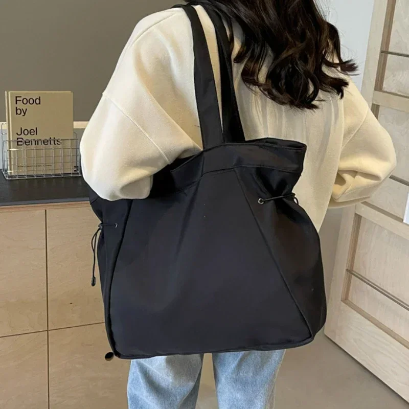 Women's large drawstring travel bag in black, aesthetic nylon shoulder bag for everyday work travel and casual use